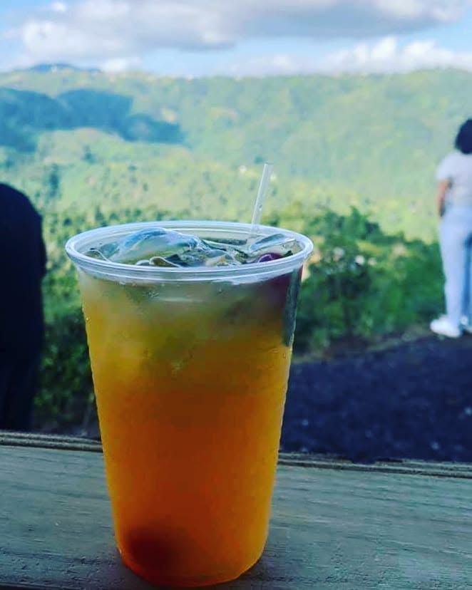 Vaso de bebida fría sobre el balcón con las montañas de fondo