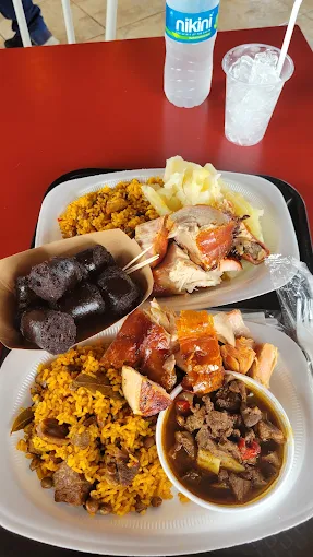 Mesa criolla con lechón asado, arroz con gandules y viandas