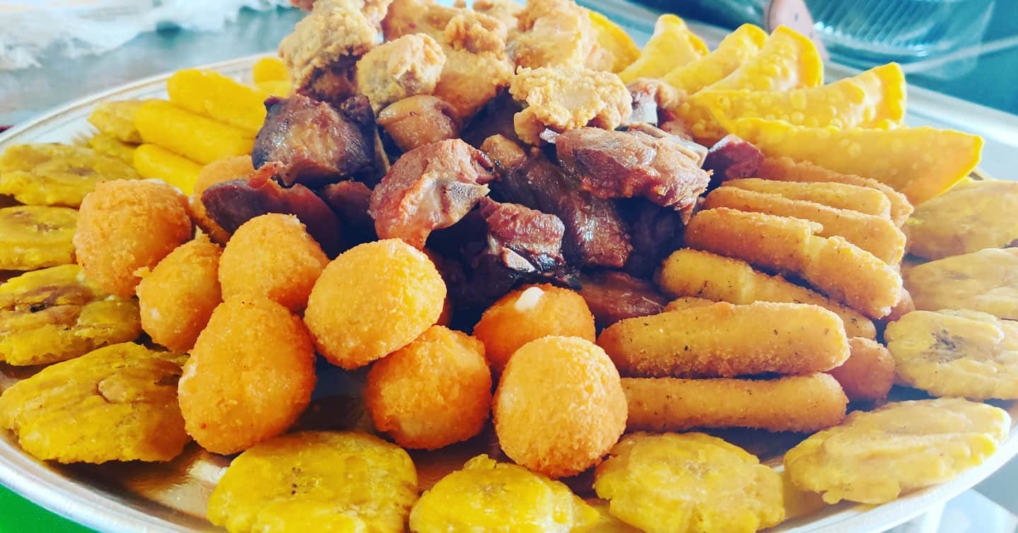 Bandeja redonda con tostones, sorullitos, empanadillas y carne frita