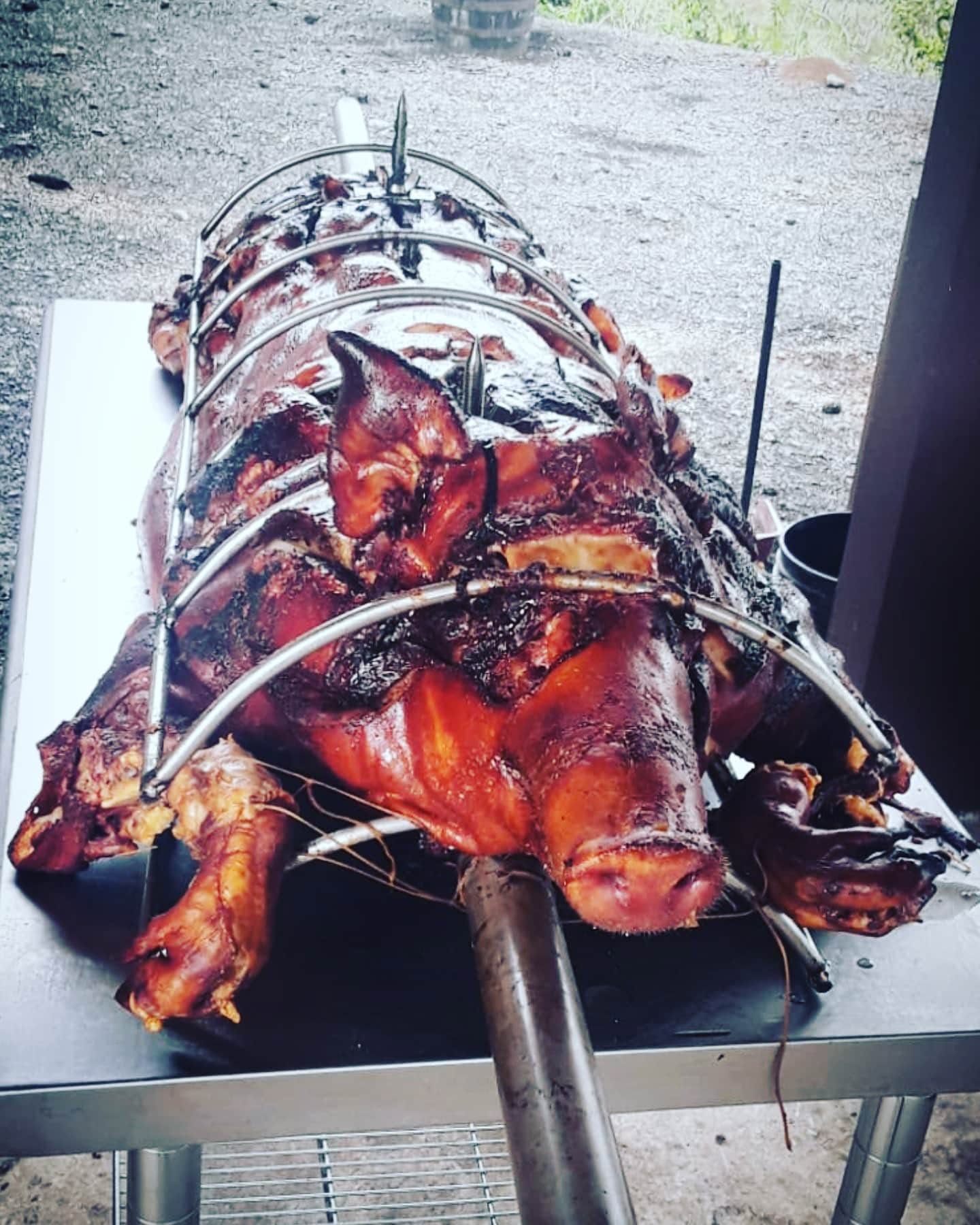 Lechón entero ensartado en una vara sobre una mesa de preparación